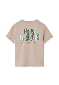 T-shirt beige à manches courtes avec texte multicolore "HOUSE OF COLORS" et impression plus petite "American Vintage" et "Depuis 2005" au dos.
