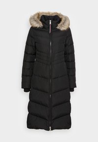 Abrigo puffer negro con capucha desmontable con trim de pelo, mangas largas, cremallera frontal y detalles en patrón de chevrones. Bolsillos forrados de forro polar.