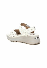 Sandalias de cuña blancas con parte superior perforada, correa ajustable y plantilla acolchada. Suela texturizada para tracción, con acento metálico.