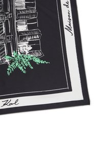 Svart silkesscarf med en vit kant och en grön illustrerad växt. Designen inkluderar detaljerade skisser av byggnader.