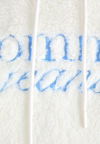 White fleece fabric with sky blue embroidered text, featuring a textured surface and white drawstrings with a metal aglet.