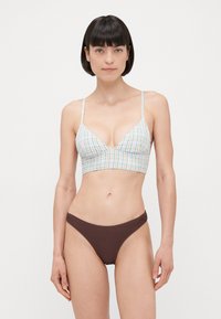 Bralettka v pastelno karirnem dizajnu z tankimi naramnicami in V-izrezom, kombinirana s temno rjavimi rebrastimi bikini hlačkami. Gladka tekstura in prilegajoča oblika.