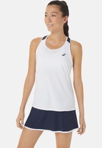 Witte sportieve tanktop met marineblauwe accenten, gecombineerd met een marineblauwe rok. Het materiaal lijkt lichtgewicht met een gladde textuur. Bevat een logo op de top.