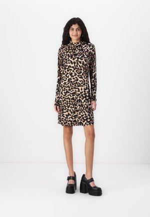 Leopardmønster langermet kjole i beige og svart, tettsittende design, myk tekstur, kombinert med kraftige svarte platåsko.