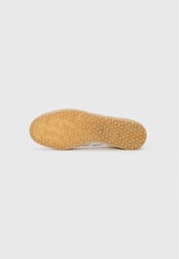 Gum rubber buitenzool met een gestructureerd oppervlak en cirkelpatroon; heeft lichte beige secties. De algehele vorm is iets afgerond aan de teen.
