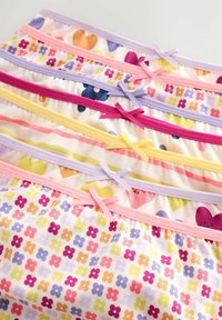 Sous-vêtements pour enfants empilés avec des motifs floraux et en forme de cœur colorés, chacun avec un petit nœud à la taille en couleurs contrastantes.