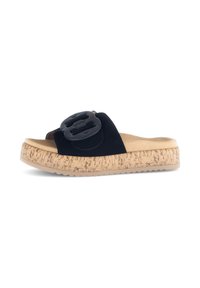 Zwarte suede slip-on sandalen met een grote zwarte gespsluiting, kurk-textuur middenzool en rubberen zool. Vlakke, open teenontwerp voor gemakkelijk aan- en uittrekken.