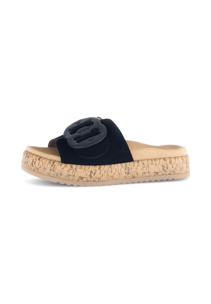 Zwarte suede slip-on sandalen met een grote zwarte gespsluiting, kurk-textuur middenzool en rubberen zool. Vlakke, open teenontwerp voor gemakkelijk aan- en uittrekken.