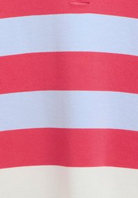 Ύφασμα με οριζόντιες ρίγες κόκκινου και λευκού χρώματος με πλεκτή υφή, που δείχνει μέρος ενός ρούχου με λεπτομέρεια γιακά στο ανώτερο κέντρο.