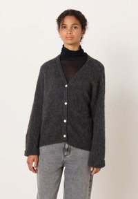 Charcoal gray cardigan made of soft, fuzzy material, featuring a V-neck, long sleeves, and five white buttons down the front.