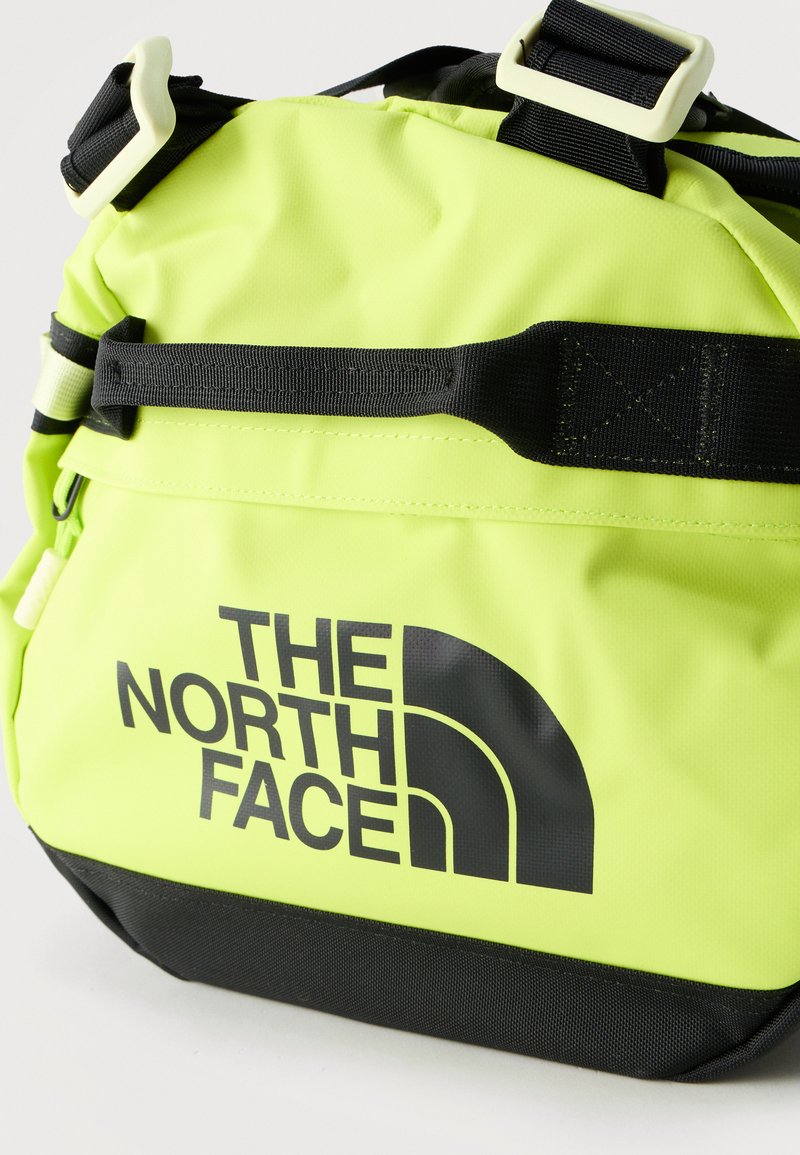 Sac The North Face jaune vif et noir avec sangle réglable noire et grand logo sur le devant.