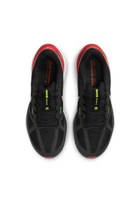 Zapatillas de deporte negras con parte superior de malla, detalles en verde neón y suela roja. Cuentan con cordones y un prominente logotipo de Nike en la lengüeta.