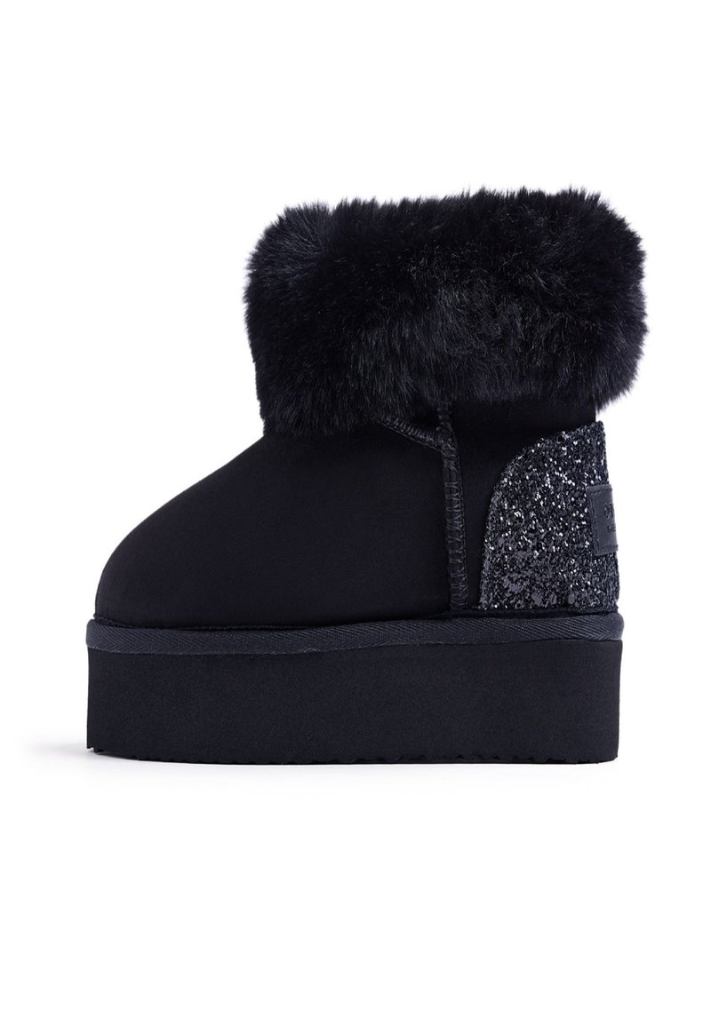 Stivaletto nero con morbida fascia in pelliccia, tomaia in suede elegante e pannello brillante testurizzato sul lato; suola piana piatta per maggiore comodità.