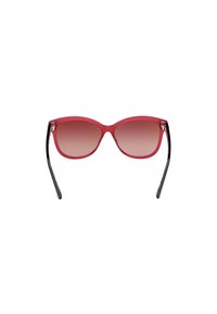 Lunettes de soleil avec un dégradé rouge et une finition brillante, de forme œil de chat et avec des branches noires. Éléments décoratifs près des gonds.