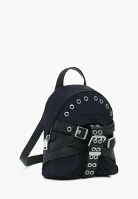 Tumesinine nailonist seljakott ümmarguse kujuga, mustadest nahkrihmadest, hõbedasest riistvarast ja dekoratiivsetest metallist augudest. Omab lukuga taskut.