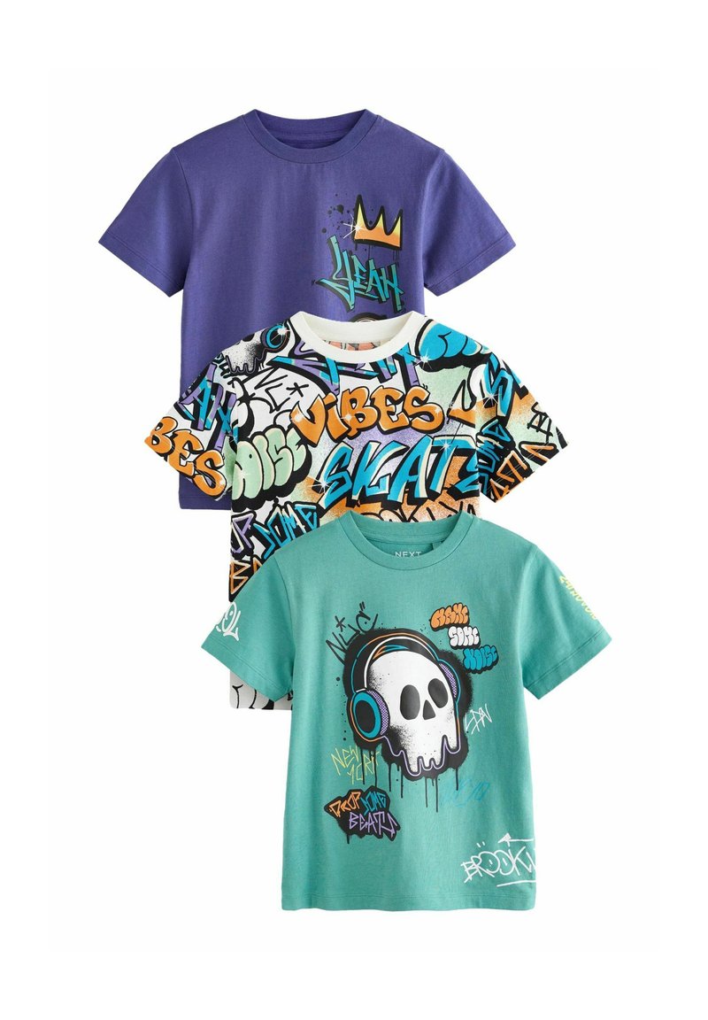 Drei Grafik-T-Shirts: ein lila Shirt mit einem Kronen-Motiv, ein weißes Shirt mit buntem Graffiti und ein türkisfarbenes Shirt mit einem Schädel und Kopfhörern.