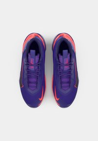 Purple athletic sneakers with a textured upper, featuring orange accents and a black swoosh logo, and a cushioned sole for comfort.