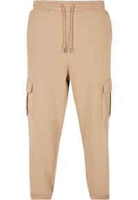Beige cargo-byxor i mjukt tyg, med ett elastiskt midjeband och dragsko samt sidofickor för funktionalitet.