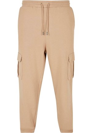 Pantalones cargo beige hechos de una tela suave, con una cintura elástica y cordón ajustable, y bolsillos laterales para mayor funcionalidad.