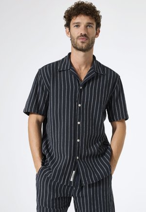 Kurzärmeliges, knöpfbares Hemd in Dunkelblau mit vertikalen weißen Streifen. Verfügt über einen breiten Kragen und einen geraden Saum, hergestellt aus leichtem Stoff.