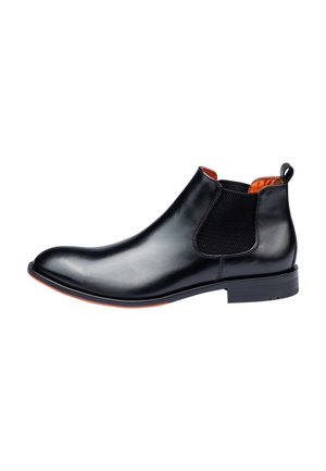 Zwarte leren Chelsea boot met elastieken zijkanten, oranje binnenvoering, gladde textuur en een subtiele rode accent op de zool.