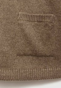 Pull en laine marron avec une petite poche en patch, un ourlet à côtes et une texture douce. Présente un tricot uniforme sur l'ensemble du tissu.