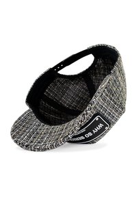 Black and white checkered cap with a curved brim, textured fabric, adjustable strap, and a white logo patch on the front.