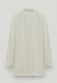 Biała lniana marynarka z klasycznym kołnierzykiem, długimi rękawami i prostym krojem. Teksturowana tkanina o subtelnej połysku, bez widocznych zapięć.