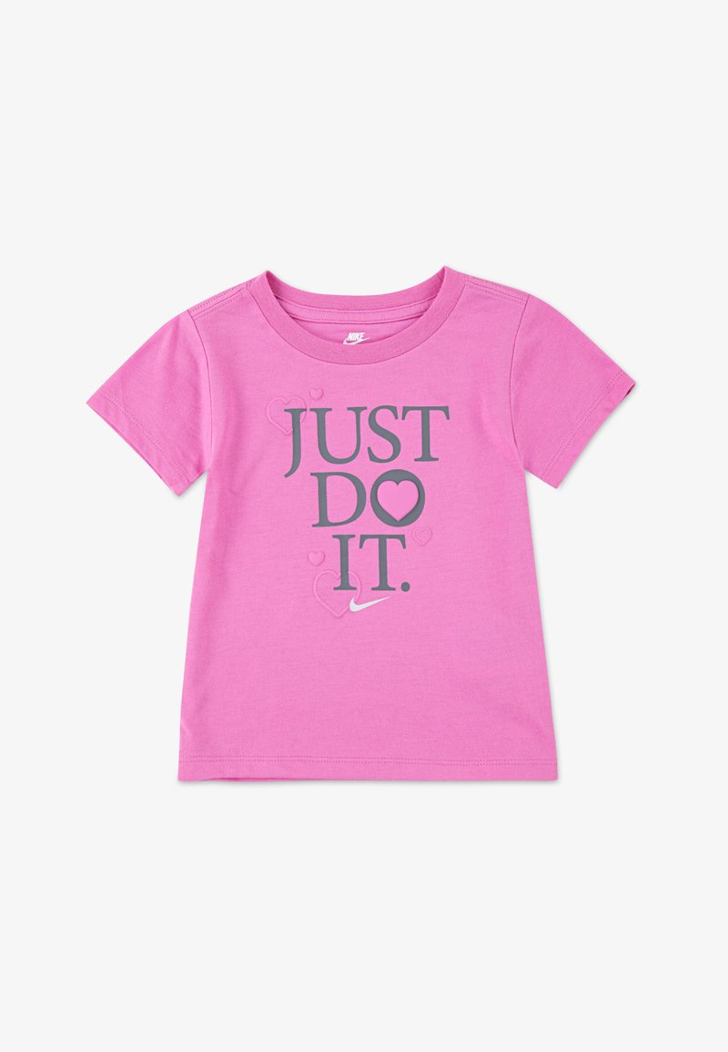Rozā kokvilnas T-krekliņš ar īsām piedurknēm, uz kura ir uzraksts "JUST DO ♥ IT." pelēkā krāsā ar sirdīšu akcentiem un nelielu Nike logotipu apakšā.