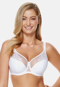 Biały stanik z fiszbinami, z przezroczystymi panelami z siateczki i haftowanymi koronkowymi detalami. Posiada regulowane ramiączka oraz dekoracyjny akcent na środku przodu.