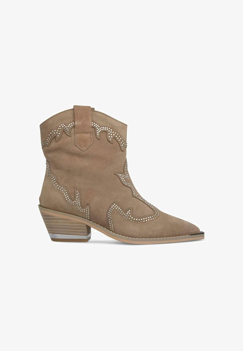Bottes de cowboy en daim beige avec un orteil pointu, des coutures décoratives en forme de vague et des accents métalliques sur un talon empilé. Onglet de préhension sur le côté inclus.