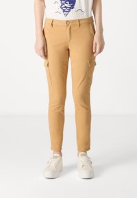 Tan cargobroeken van katoen, met een slim fit, twee zijzakken en een knoopsluiting. Gecombineerd met witte sneakers.