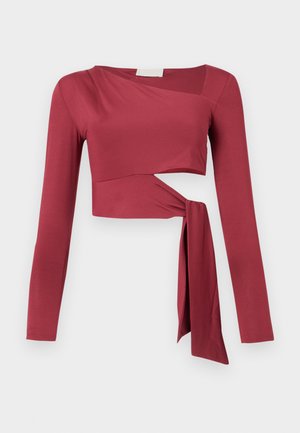 Bordo dolgimi rokavi zgornji del s skrajšanim dizajnom in stransko vezavo. Gladek, raztegljiv material z rahlo drapiranim izrezom.