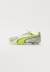 Botas de fútbol en blanco, gris y verde neón. Presentan un diseño de malla, patrones elevados y una suela texturizada con tachuelas cónicas para una mejor tracción.
