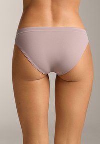 Let lyserød bikiniundertøj, glat stof, design med lav talje, minimal syning, blød tekstur, sidder tæt til kroppen.