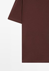 Donkerbruin T-shirt met korte mouwen en zichtbare zoomstiksels aan de mouw en onderkant, op een witte achtergrond.