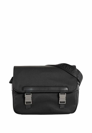 Sac messager noir en nylon avec une texture lisse. Présente un rabat, deux fermetures à boucle en métal et une bandoulière réglable avec logo.