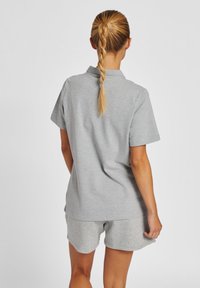 Grau Polo-Shirt mit kurzen Ärmeln und passender Hose aus strukturiertem Baumwollstoff. Verfügt über einen klassischen Kragen und einen lässigen Schnitt.
