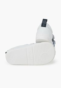 Scarpe bianche per bambini con suola in gomma, dotate di un inserto navy e accentuazioni grigie, tomaia testurizzata e chiusure a strappo. Taglia 21.
