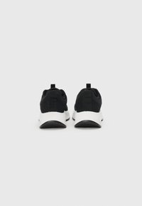 Black athletic shoes with a textured upper, white sole, and contrasting accents. Features a pull tab at the heel for easy wear.
