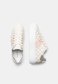 Sneaker bianche con un motivo beige testurizzato, dettagli rosa e un tallone grigio. Presenta lacci e una suola in gomma piatta.