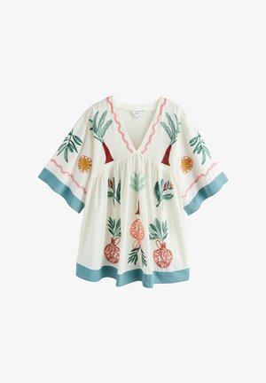 Hvid løs tunika med vide ærmer, blå kant og farverige broderede træer, blade, sole og vaser på forsiden og ærmerne.