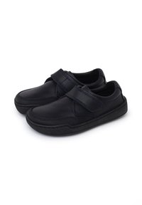 Scarpe nere in pelle con una striscia in Velcro, caratterizzate da un design texture e una suola in gomma. Punta arrotondata e dettagli di cucitura a contrasto.