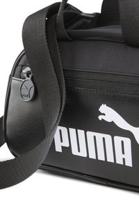 Borsa da palestra nera in materiale sintetico, con un grande logo bianco "PUMA", zip nera e tracolla regolabile.