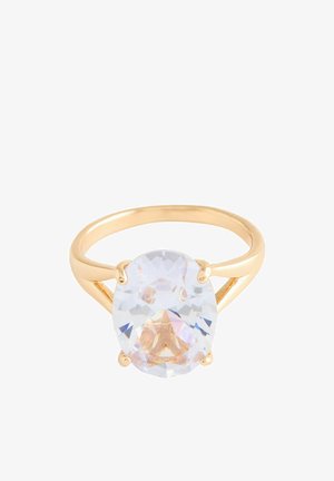 Gold ring with a large oval clear gemstone held by four prongs, featuring a split shank design on a white background.