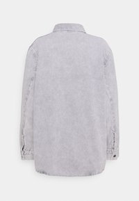 Chemise en velours côtelé gris clair à manches longues avec col, vue de dos sur fond blanc.