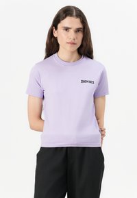Fialové tričko s krátkým rukávem vyrobené z měkké bavlny. Má kulatý výstřih a černé logo "DICKIES" na levé části hrudi.