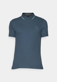 Polo bleu à manches courtes pour homme, avec patte de boutonnage à deux boutons, bordure contrastante sur le col et les manches, et petit logo carré sur la poitrine gauche.
