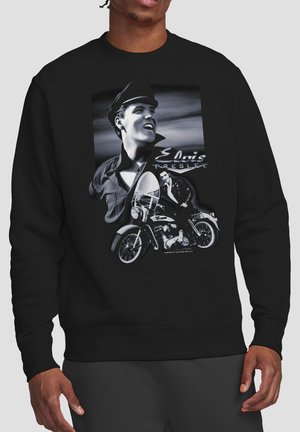 Black sweatshirt with black-and-white graphic of Elvis Presley smiling and sitting on a vintage motorcycle with his name in script.