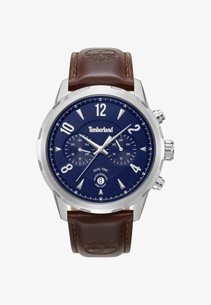 Timberland Dual-Time-Uhr mit einem Edelstahlgehäuse, blauem Zifferblatt, silberfarbenen Markierungen und braunem Lederarmband mit Logo-Akzent.